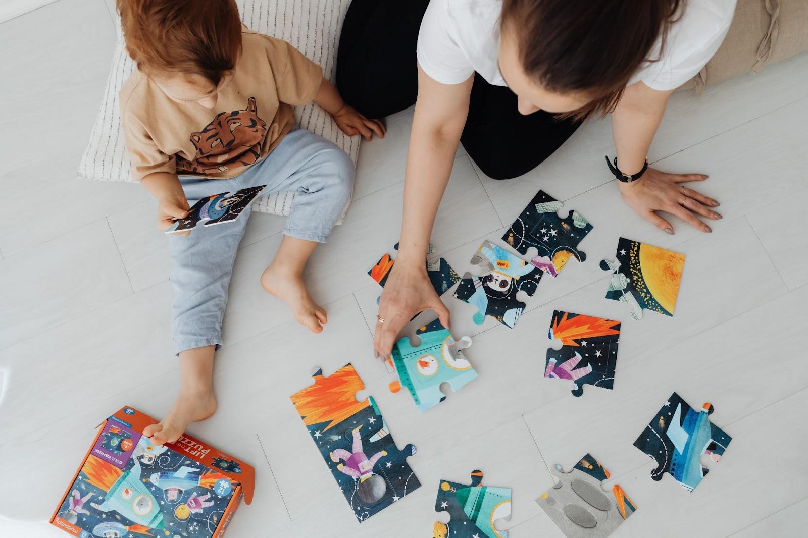 Mother is playing puzzle with little boy