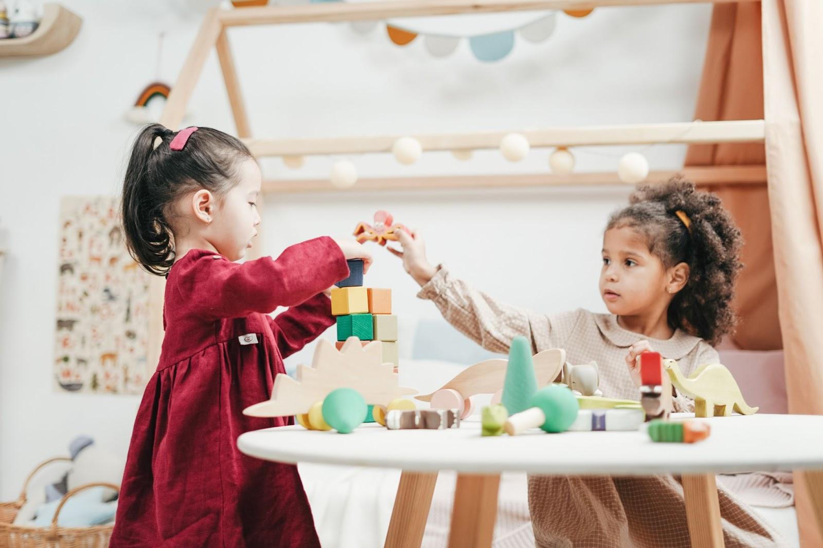 Little girls playing with wooden toys